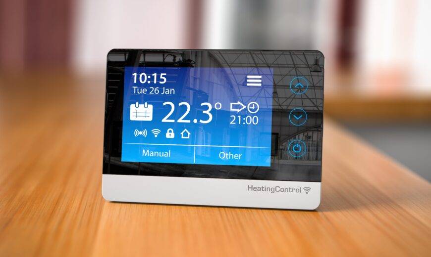 A smart digital thermostat sitting on a counter.