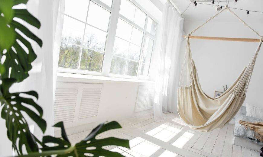 A large window shining natural light into a white room.