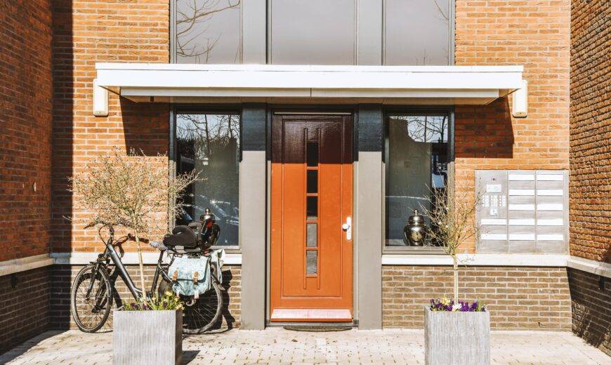 The front of a house with a terracotta door door.