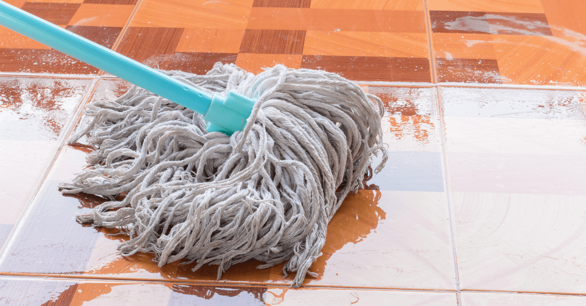 Mopping wet tile flooring.